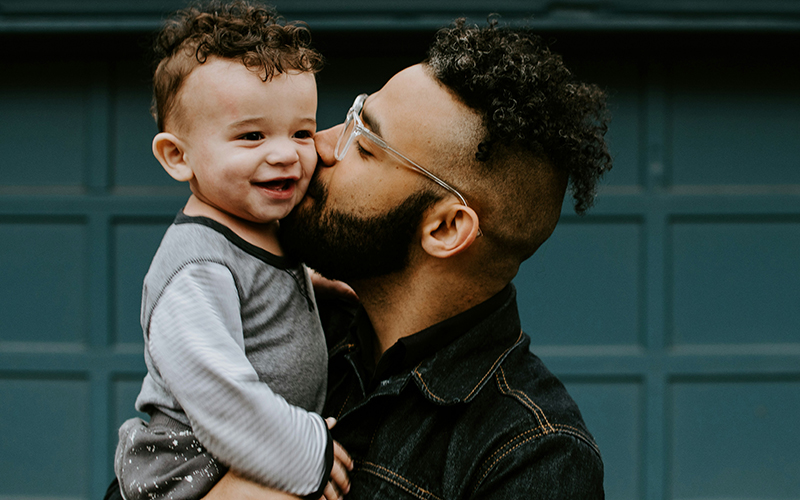 dad kissing his child